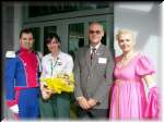 Dave Darlington sharing flowers with his staff, Penny MacLennan, flanked by Lajkonik dancers.