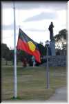 NAIDOC WEEK  2010. Flag raising ceremony at Banjo Paterson Park, Jindabyne. The Strzelecki monument can be seen right behind the Aboriginal flag.